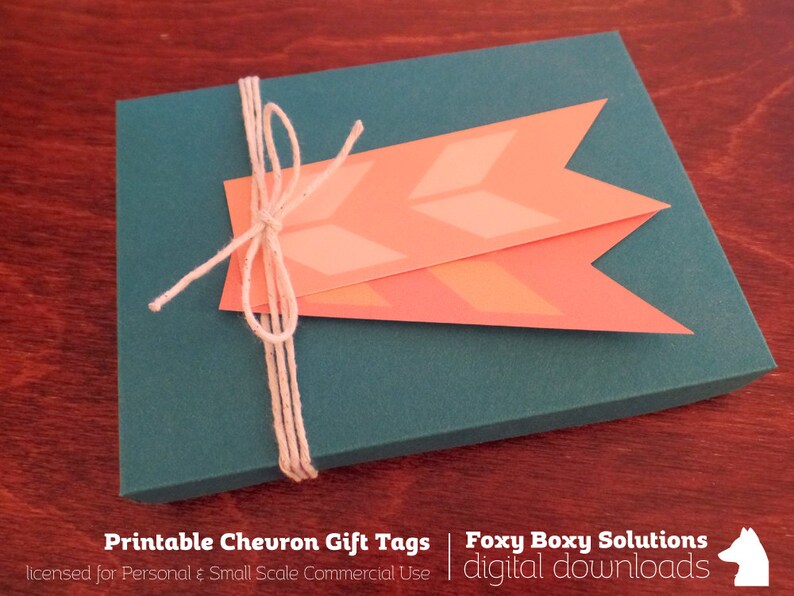 May include: A teal gift box with a white twine bow and two peach chevron gift tags. The text on the tags reads "Printable Chevron Gift Tags" and "Foxy Boxy Solutions digital downloads".