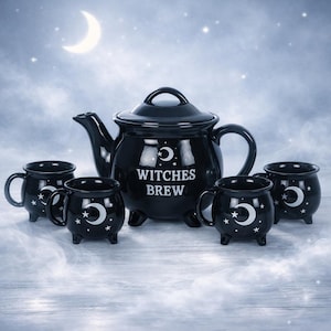 Può includere: Una teiera in ceramica nera e quattro tazze abbinate a forma di calderone, decorate con motivi bianchi di lune crescenti e stelle. La teiera riporta la scritta WITCHES BREW in lettere bianche. Ogni pezzo è dotato di tre piccoli piedini.