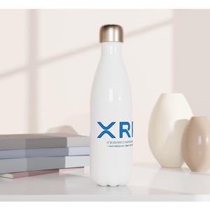 May include: A white metal water bottle with a silver cap, featuring the blue text XRI and smaller black text below it. The bottle has a smooth, cylindrical body that tapers towards the top, standing upright with a clean, minimalist design aesthetic.