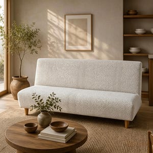 May include: A cream-colored sofa featuring a textured, geometric jacquard pattern across the backrest and seat. The sofa is supported by four light-toned wooden legs and has a structured, armless design with a clean, straight-edged silhouette.