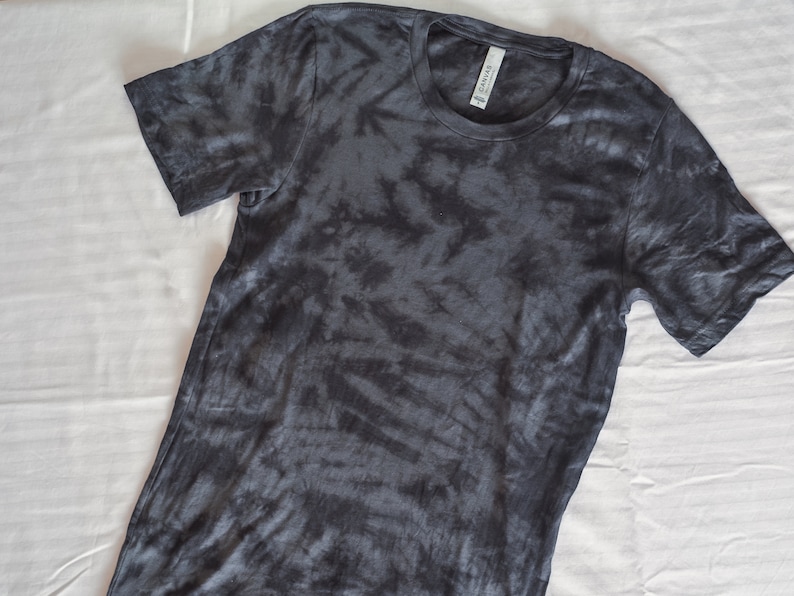 May include: A dark gray tie-dye t-shirt with a crew neck.
