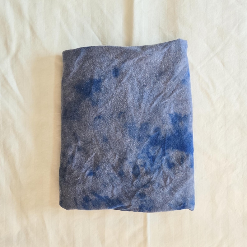 May include: A blue and gray tie-dye fabric with a swirled pattern.