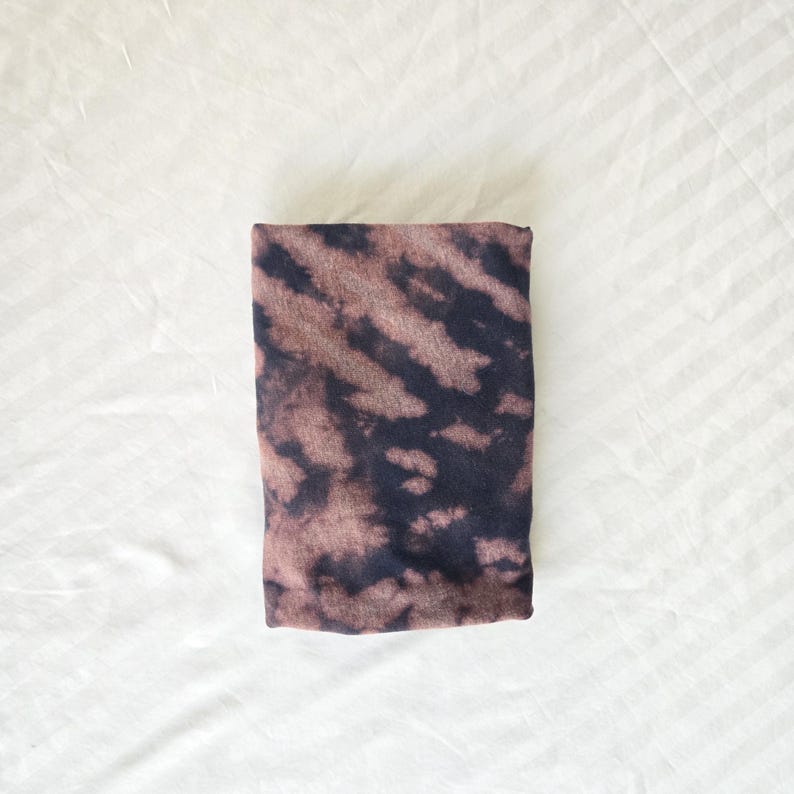 May include: A black and brown tie-dye fabric with a swirled pattern.