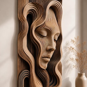 May include: A rectangular wall art piece crafted from layered, light and dark brown wood strips. The layered construction forms a three-dimensional relief of a human face with closed eyes, flowing hair, and a nose, creating a wavy, textured surface.