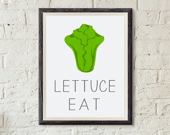 Op de afbeelding: Een ingelijst print met een groene sla-illustratie en de tekst "Lettuce Eat" in zwart.