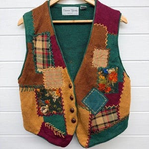 May include: A sleeveless knit waistcoat featuring a patchwork design with various colours including green, mustard yellow, and burgundy. The waistcoat includes multiple fabric patches with floral and plaid patterns, four brown buttons, and a Sharon Young label.