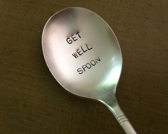 Puede incluir: Una cuchara de plata con las palabras "Get Well Spoon" grabadas en la parte delantera.