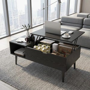 Puede incluir: Una mesa de centro de madera oscura con mecanismo elevable, que cuenta con un estante lateral abierto y un compartimento de almacenamiento oculto. La superficie de la mesa sostiene un portátil, un ratón y una taza de café.