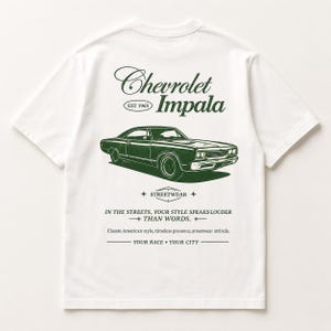 Op de afbeelding: Een wit T-shirt met korte mouwen en een donkergroene afbeelding van een Chevrolet Impala. De tekst luidt: Chevrolet Impala EST 1965, STREETWEAR, IN THE STREETS, YOUR STYLE SPEAKS LOUDER THAN WORDS, Classte American style, timeless presence, streetwear attinde, YOUR RACE • YOUR CITY.