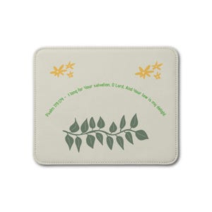 Op de afbeelding: Een rechthoekige, gebroken witte muismat met een groene rankafbeelding onderaan en twee clusters gele bloemen bovenaan. De tekst "Psalm 119:174 - I long for Your salvation, O Lord. And Your law is my delight." is in het groen gedrukt.
