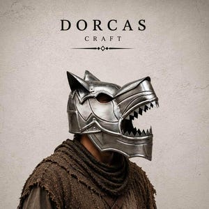 Pode incluir: Um capacete metálico em forma de lobo com orelhas pontiagudas e mandíbula aberta com dentes afiados. O capacete é prateado com rebites visíveis e placas segmentadas. Acima do capacete, o texto DORCAS CRAFT está impresso em preto.