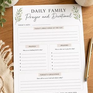 Puede incluir: Una hoja de papel blanca titulada Daily Family Prayer and Devotional con ilustraciones de hojas verdes en las esquinas superiores. El diseño incluye secciones para la fecha, versículos, alabanzas, oraciones y un desafío diario con líneas.