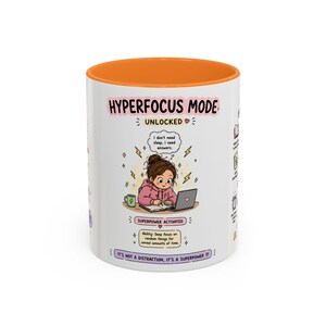 Puede incluir: Una taza de cerámica blanca con interior naranja que presenta una ilustración de dibujos animados de una persona trabajando en una computadora portátil. El texto dice HYPERFOCUS MODE UNLOCKED, I don't need sleep, I need answers, SUPERPOWER ACTIVATED e IT'S NOT A DISTRACTION, IT'S A SUPERPOWER.