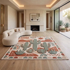 May include: A rectangular area rug featuring a tufted desert-themed pattern with sage green cacti, rounded succulents, and terracotta-colored abstract shapes on a cream background, accented by a border of semi-circles and sun motifs.