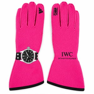 Peut inclure: Une paire de gants de course rose vif avec une texture en maille noire. Le gant gauche affiche un graphique imprimé d'une montre IWC au cadran noir. Le gant droit présente le texte noir OMP et IWC SCHAFFHAUSEN avec un logo Adidas.