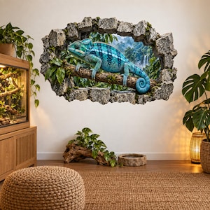 May include: A wall decal featuring a 3D-style hole in a stone wall, revealing a vibrant blue chameleon perched on a tree branch within a lush jungle setting with a waterfall in the background. The design creates an illusion of depth and texture.