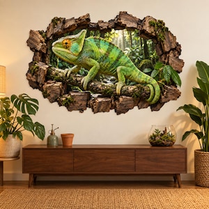Op de afbeelding: Een muursticker met een 3D-effect gat in de muur, dat een groene kameleon op een bemoste boomtak in een bos laat zien. De rand van het gat is omlijst door gestructureerde, donkerbruine boomschors en stukjes groen mos.