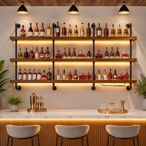 May include: A three-tier wall-mounted bar shelf constructed from dark wood planks and black industrial pipe supports, featuring integrated LED lighting. The shelves hold various glass liquor bottles, while the bar counter below includes metal shakers.