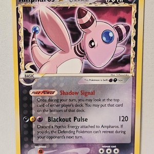 May include: A trading card featuring the character Ampharos Delta Species with 170 HP. The card displays the text Shadow Signal and Blackout Pulse, with a purple and yellow color scheme. It is labeled as an unofficial custom card at the bottom.