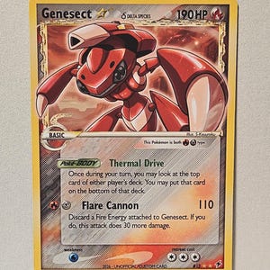 May include: A Genesect trading card with 190 HP, featuring a red robotic creature illustration. The card text includes Thermal Drive, Flare Cannon, and Delta Species. It is labeled as a 2026 unofficial custom card with a fire energy symbol.