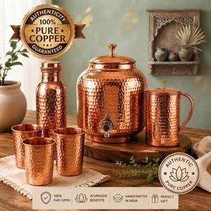May include: A set of hammered copper drinkware including a large water dispenser with a spigot, a tall bottle, a pitcher with a handle, and three matching tumblers. The items feature a textured finish and are labeled as 100% pure copper.