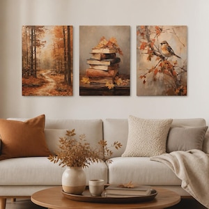 Könnte beinhalten: Ein Set aus drei rechteckigen Wandbildern mit herbstlichen Motiven. Das linke Bild zeigt einen Waldweg, das mittlere Bild einen Stapel alter Bücher mit herbstlichen Blättern und das rechte Bild einen kleinen Vogel auf einem Ast.