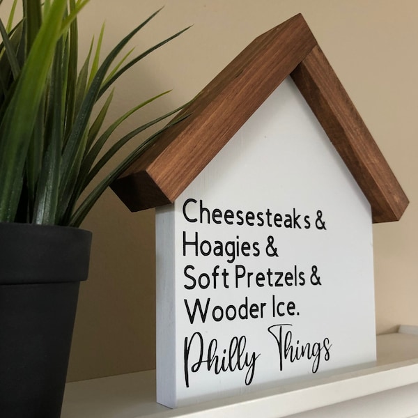 Letrero de madera con los favoritos de Filadelfia: filetes de queso, sándwiches hoagies y pretzels suaves