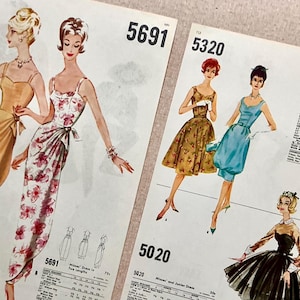 May include: Two vintage sewing pattern envelopes labeled 5691, 5320, and 5020. The illustrations feature various dress styles including a solid gold sheath, a floral print wrap dress, a patterned full-skirted dress, a blue dress, and black dresses.