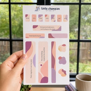 May include: A sticker sheet featuring a narwhal logo for little champion studio, with daily labels from Mon to Sun, and text prompts including Distractions & distractors, I am blocking out this week, Small sparks of good, and Not everything requires my reaction.