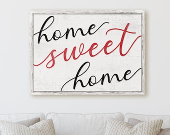 May include: White wooden sign with the text "home sweet home" in black and red cursive lettering.