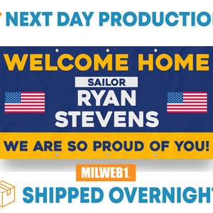 May include: A blue and yellow welcome home banner with the text "Welcome Home Sailor Ryan Stevens We Are So Proud Of You!" and two American flags. The banner is for a military homecoming.