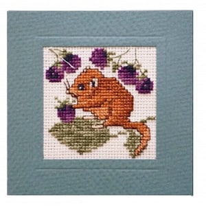 May include: A cross-stitch design featuring a small, orange-brown mouse-like creature with a long tail, eating purple berries. The creature is surrounded by green leaves and more purple berries.