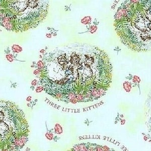 May include: A light blue fabric with a repeating pattern of three kittens playing in a green field with pink flowers. The text "Three Little Kittens" is printed in brown below the kittens.