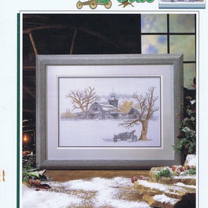 May include: A framed cross-stitch design of a winter scene with a barn and trees. The title of the design is "Pieces of Olde" by Mark Polomchak.