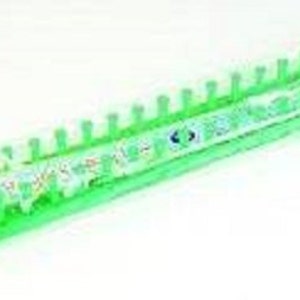 May include: Green plastic knitting loom with 40 pegs. The loom is packaged in clear plastic.