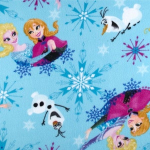 May include: A blue fabric with a repeating pattern of snowflakes, Olaf the snowman, and the characters from the movie Frozen. The characters are Elsa and Anna, who are wearing their signature dresses.