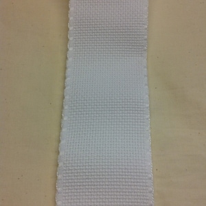 May include: White woven elastic trim with a scalloped edge.