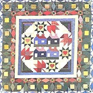 May include: A patchwork quilt with a central design of houses, stars, and hearts in red, blue, and yellow. The quilt has a white border and a patterned outer edge with geometric shapes. The overall theme is Americana.