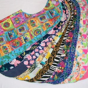 May include: A collection of colorful fabric pieces, each with a unique pattern. Designs include floral, geometric, and animal prints. The fabrics are arranged in a fan shape, showcasing the variety of colors and styles.