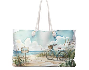 Puede incluir: Una bolsa de lona blanca con un diseño de acuarela de una escena de playa con una bicicleta azul y un cartel de madera que dice "Playa".