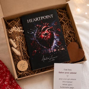 Peut inclure: Une boîte cadeau en carton contenant le livre HEARTPOINT 1 d'Abelia Lewis avec une couverture sombre illustrée d'un cœur anatomique rouge, un petit bouquet de fleurs séchées, un objet en forme de cœur marron et une carte avec du texte français.