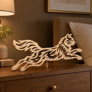 May include: A light-colored wooden cutout sculpture of a cat in a leaping pose. The cat features intricate, flame-like cutouts throughout its body, tail, and fur, creating a stylized, openwork design supported by a small vertical base.