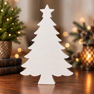 Peut inclure: Une décoration de sapin de Noël en bois blanc sur pied avec une finition lisse et une étoile au sommet. La silhouette présente des branches étagées et une base solide, conçue comme un ornement plat pour une présentation sur table.