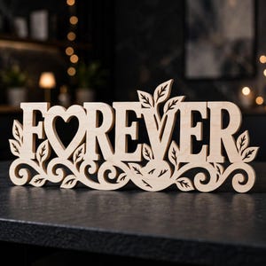 May include: A light-colored wooden sign featuring the word FOREVER in a bold, serif font. The letter O is replaced by a heart shape. The base and sides are decorated with intricate, swirling vine patterns and leaf cutouts integrated into the design.