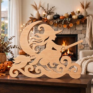 May include: A light-colored wooden cutout featuring a silhouette of a figure wearing a pointed hat, riding a broomstick in front of a crescent moon, with decorative swirling cloud-like patterns at the base of the design.