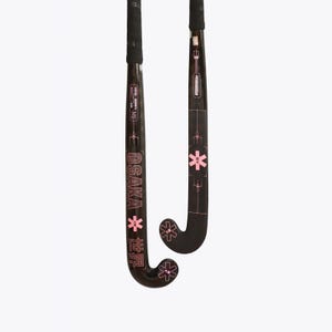 May include: Two black field hockey sticks with pink graphic accents. The sticks feature the text OSAKA, a pink star-like logo, and Japanese characters. The handles are wrapped in black grip tape, and the curved heads display matching pink star icons.