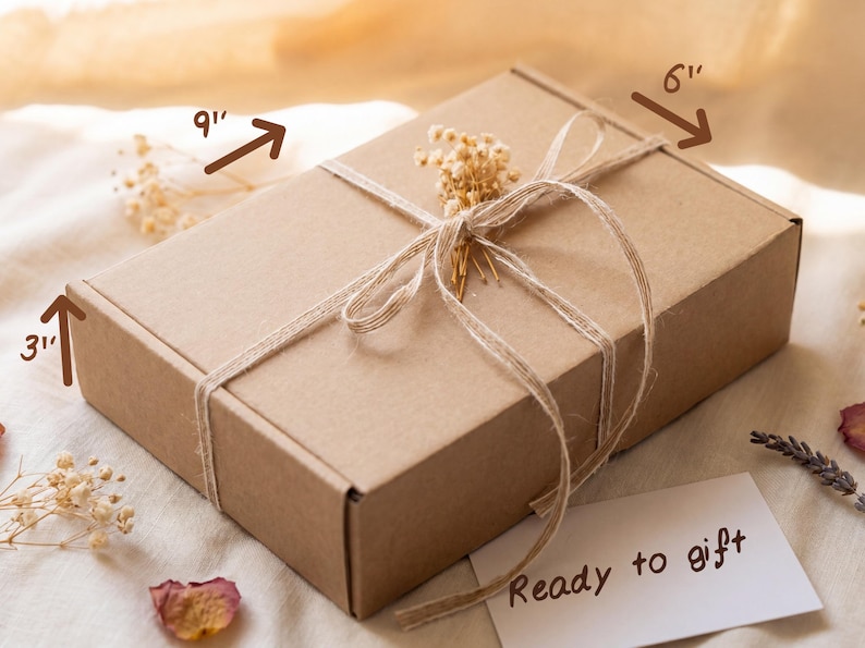 May include: A rectangular brown cardboard box tied with thin twine and decorated with a small sprig of dried white flowers. The box dimensions are labeled as 9 inches long, 6 inches wide, and 3 inches high. A white card with the text Ready to gift.