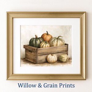 Puede incluir: Una impresión artística enmarcada que presenta una pintura de varias calabazas dentro y alrededor de una caja de madera. Las calabazas son de tonos verdes, naranjas y crema. El marco es dorado con un paspartú blanco. El texto Willow & Grain Prints es visible.