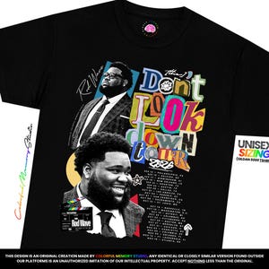May include: A black t-shirt featuring a graphic print of Rod Wave in a suit, the text "Don't Look Down Tour 2026", a list of tour dates and cities, and a small film clapperboard graphic with the text "Rod Wave" printed on the front of the garment.