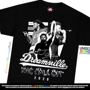 May include: A black t-shirt featuring a graphic print of the artist J. Cole in three different poses. The design includes the text "Forest Hill Drive", "Dreamville", "THE FALL OFF", and "2026". The shirt also displays a small "UNISEX SIZING" label.